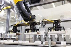 A six-axis robot erects cardboard inlays. Photo R Weiss
